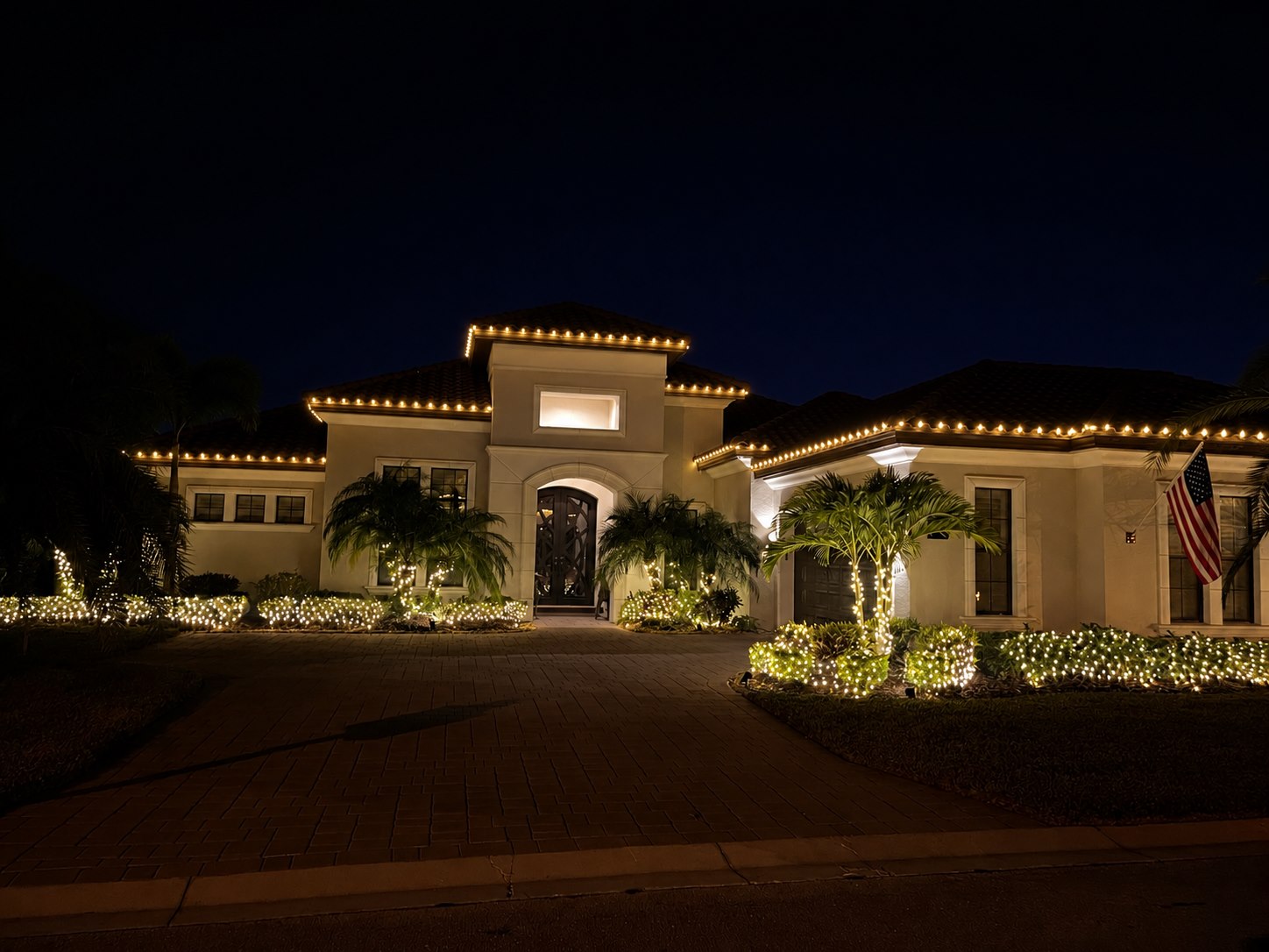 Our warm white holiday installation on a Florida home, with illuminated palms and landscaping